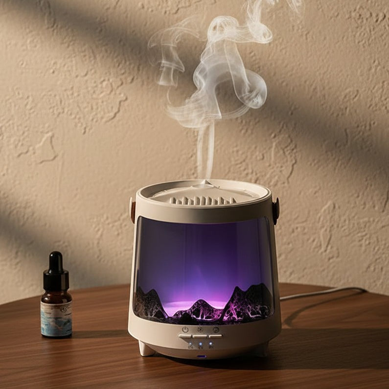 Glow & Drift Aurora Mist & Flame Diffuser with purple LED light, mountain landscape, and mist rising on a wooden table.