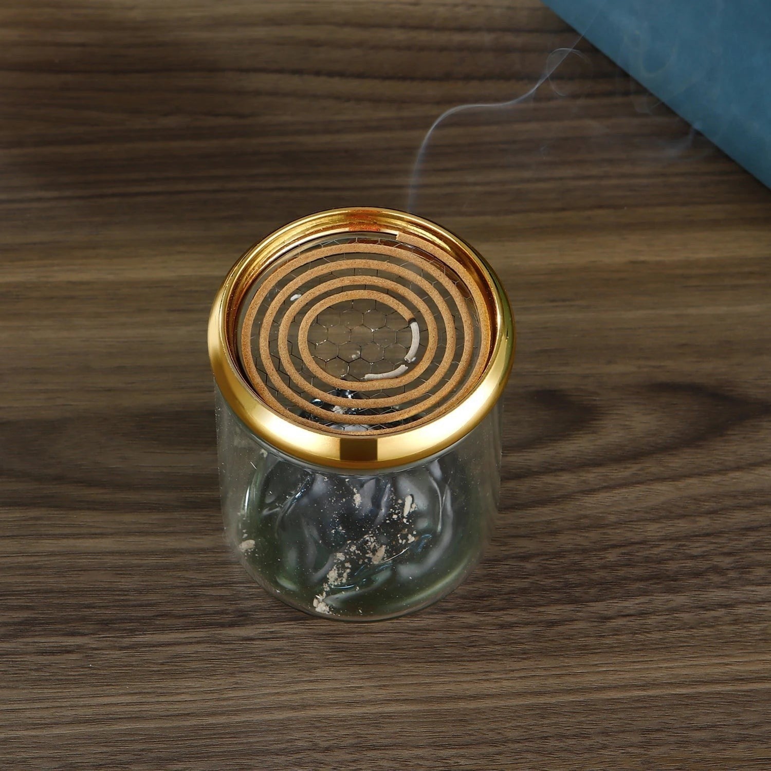 Glow & Drift Azure Peak backflow incense burner with a blue glass mountain, clear cylinder, and golden mesh lid.