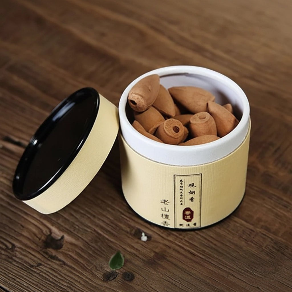 Glow & Drift botanical incense canister containing natural wood backflow cones in a minimalist cylindrical tube