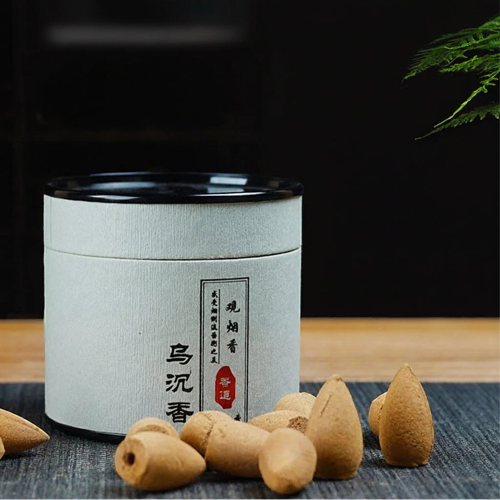 Glow & Drift botanical incense canister with natural wood backflow cones on a dark textured surface