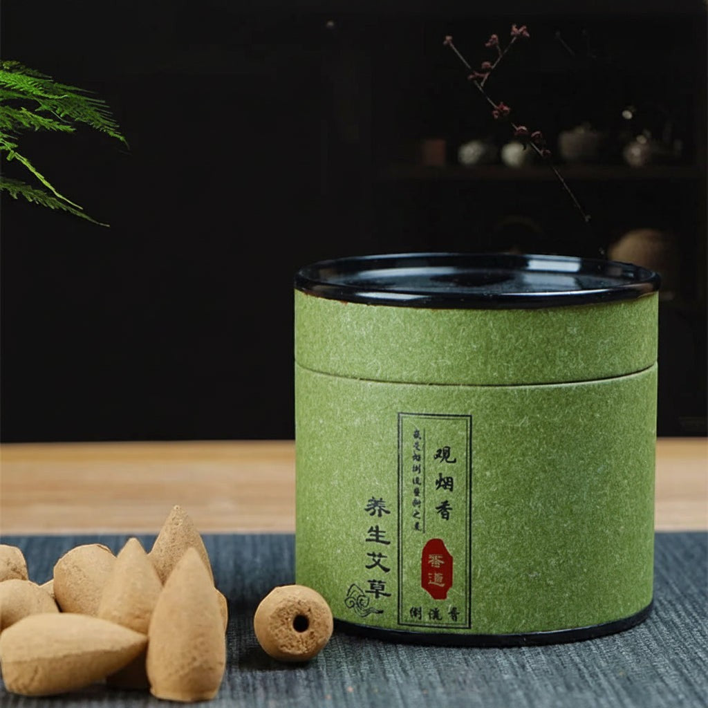 Glow & Drift botanical incense cones with a green cylindrical storage canister on a wooden table for meditation