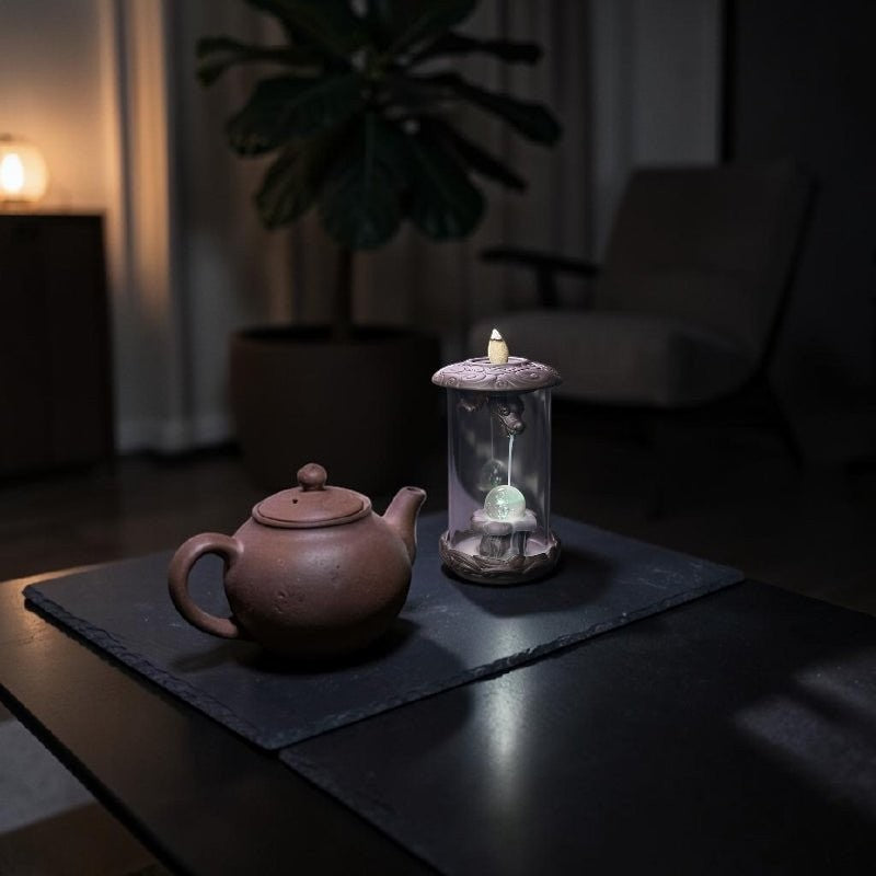Glow & Drift Aurelian Dragon Glass Tower incense burner with Zisha clay dragon and glowing orb on a dark table.