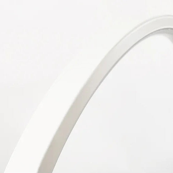 Close-up of the white curved frame of the Glow & Drift Eclipse Triple Ring Table Lamp against a plain background
