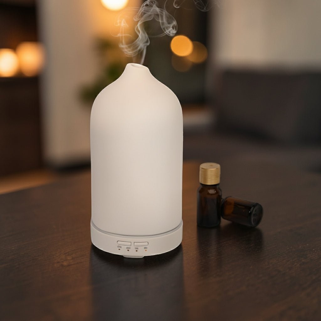 Glow & Drift minimalist frosted ceramic essential oil diffuser emitting a cool mist on a dark wooden table.