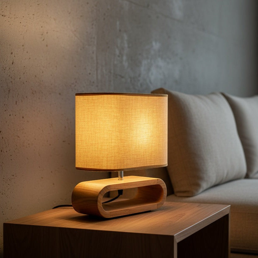 Glow & Drift Koto Japandi table lamp with a solid wood base and warm glowing linen shade on a wooden side table