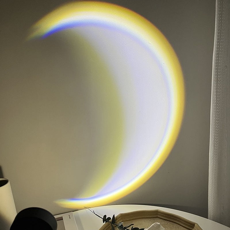 Glow & Drift Lunar Crescent Aura Light projecting a vibrant yellow and blue crescent moon glow on a bedroom wall