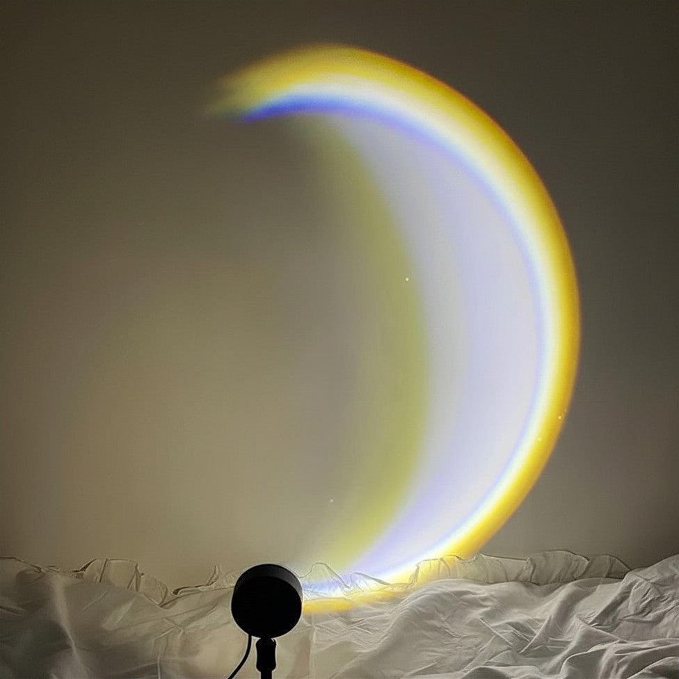 Glow & Drift Lunar Crescent Aura Light projecting a vibrant yellow and blue crescent moon glow on a bedroom wall