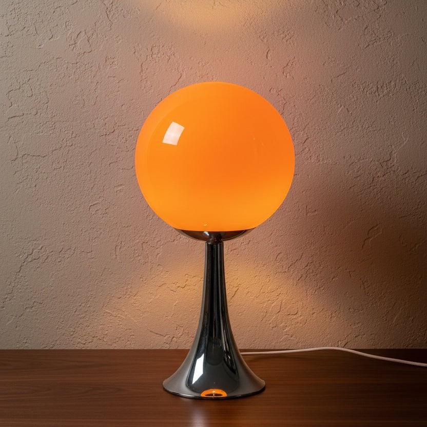 Glow & Drift Solis Glass Globe Lamp with a bright orange spherical shade and a polished chrome trumpet-style base.