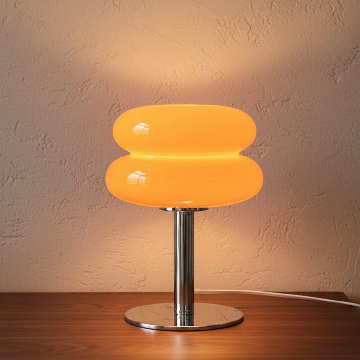 Glow & Drift retro macaron glass lamp with a vibrant orange mushroom shade and polished steel base on a wood table.