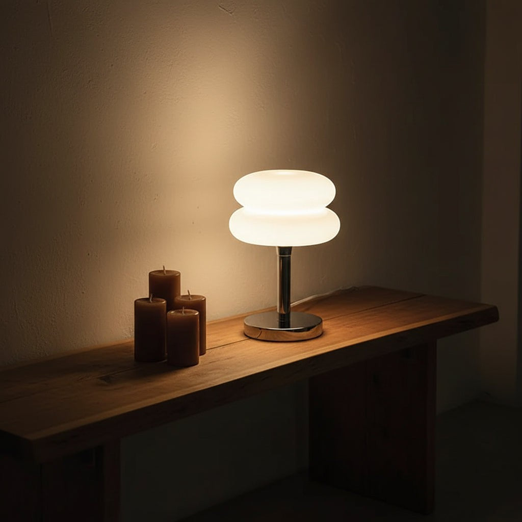Glow & Drift Retro Macaron glass lamp with a polished steel base emitting a soft warm glow on a wooden bench.