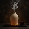 Glow & Drift Earthen Vase aroma diffuser with ribbed resin texture emitting a gentle mist on a dark moody surface.