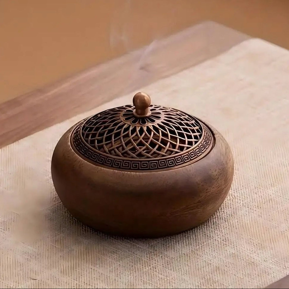 Glow & Drift solid wood incense burner with an intricate antique-style metal lid emitting a wisp of fragrant smoke.