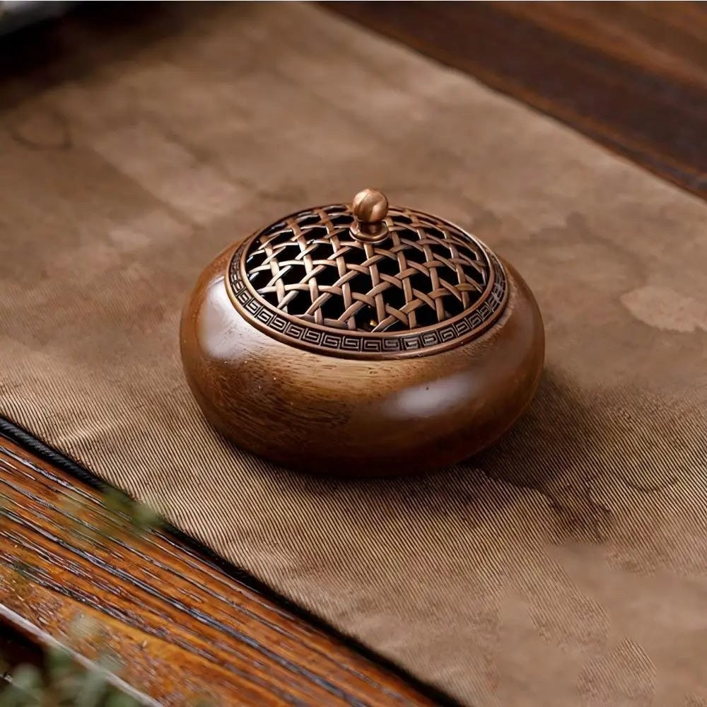 Glow & Drift Heritage solid wood incense burner with an intricate antique-style metallic lattice lid on a table.