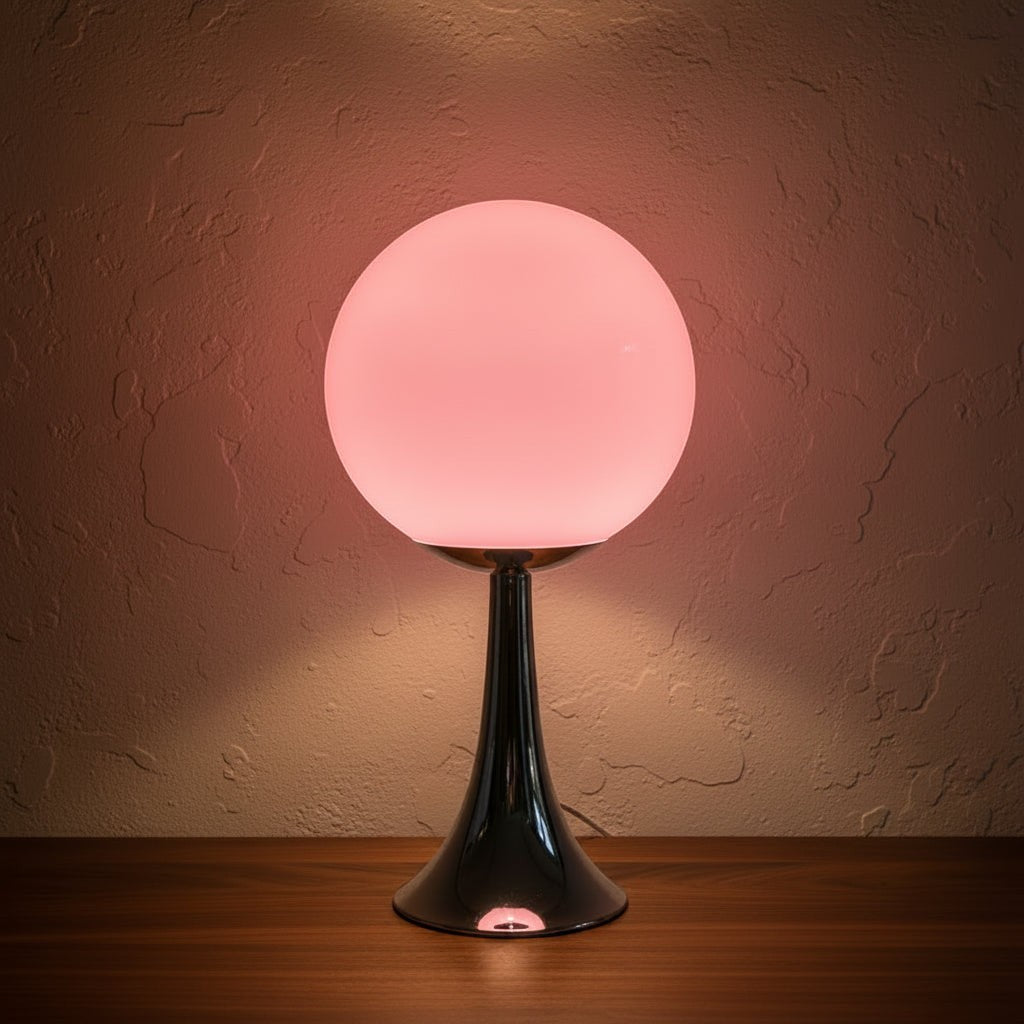 Glow & Drift Solis Glass Globe Lamp with a glowing pink spherical shade and a polished chrome trumpet-style base.