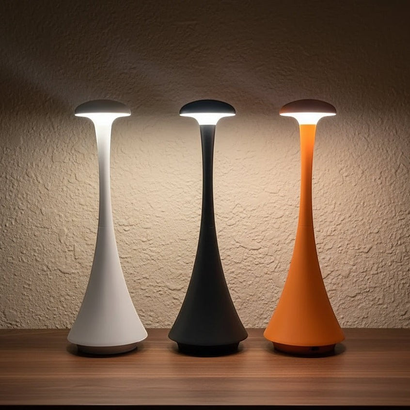 Glow & Drift Spora portable mushroom lamps in white, black, and orange with soft ambient lighting on a wooden table.