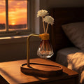 Glow & Drift Elara suspended reed diffuser with acacia wood base, brass arm, and diamond glass vessel on a nightstand.