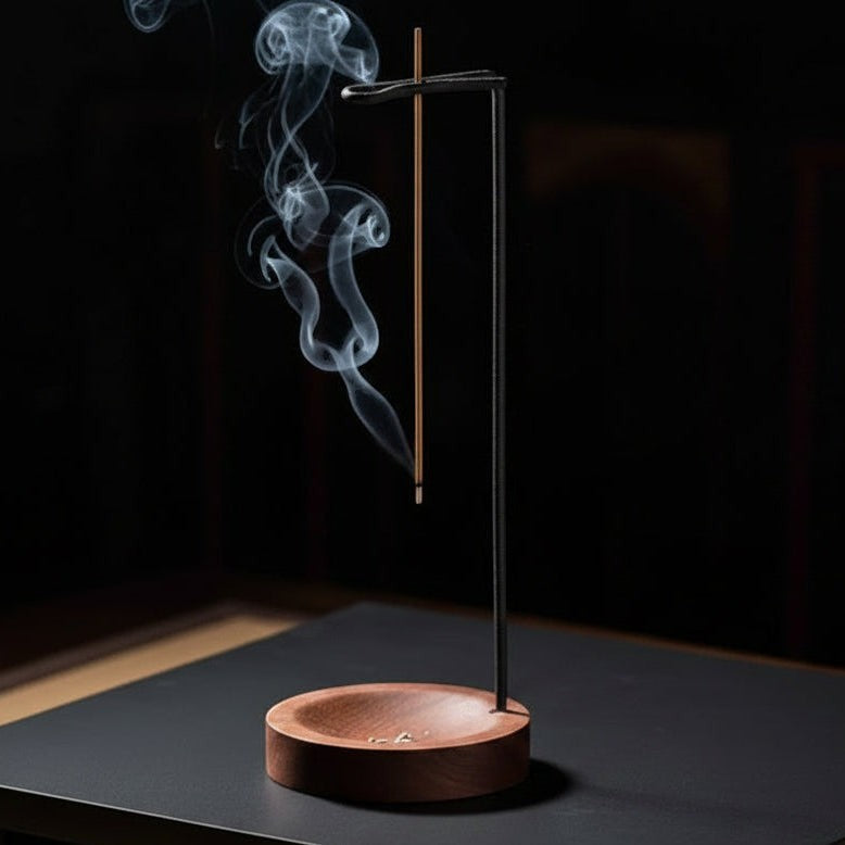 Glow & Drift Equinox walnut wood incense stand with a vertical metal arm holding a burning incense stick over a tray
