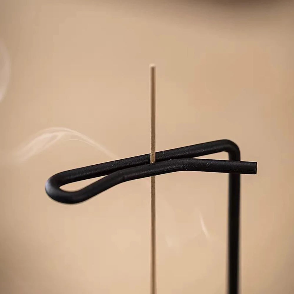 Glow & Drift Equinox walnut incense stand with a black metal arm holding an incense stick for a clean vertical burn