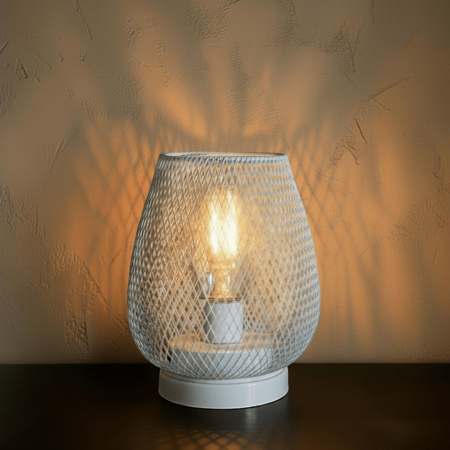 Glow & Drift Lumina cage lamp with a white iron mesh frame and warm Edison filament bulb casting intricate shadows.