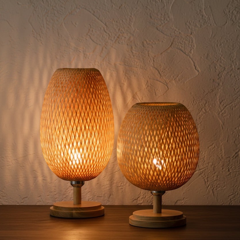 Glow & Drift woven bamboo lamps in cocoon and globe shapes with warm light casting geometric shadows on a textured wall.