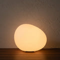 Glow & Drift Zen Riverstone ambient lamp with a smooth, frosted acrylic cobblestone shape emitting a warm, soft glow.