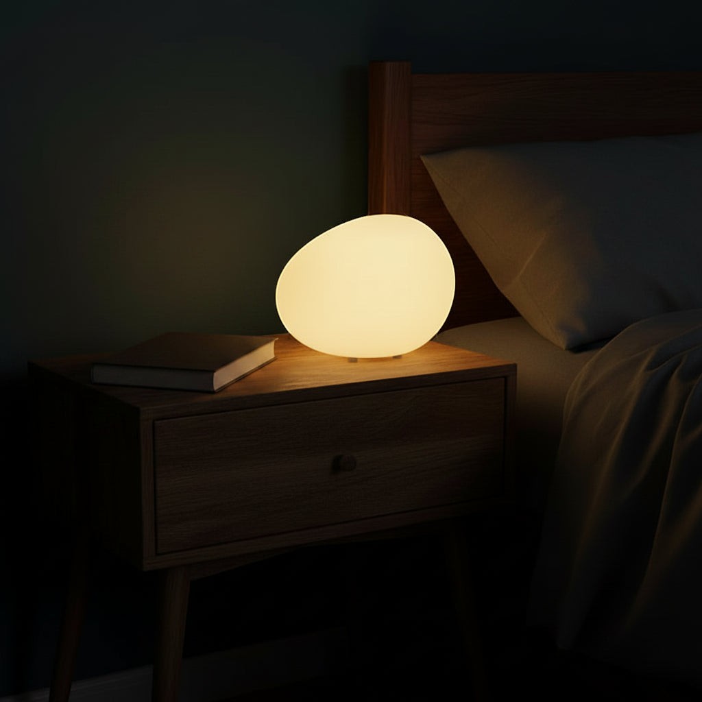 Glow & Drift Zen Riverstone ambient lamp with a frosted acrylic cobblestone design glowing on a wooden nightstand.