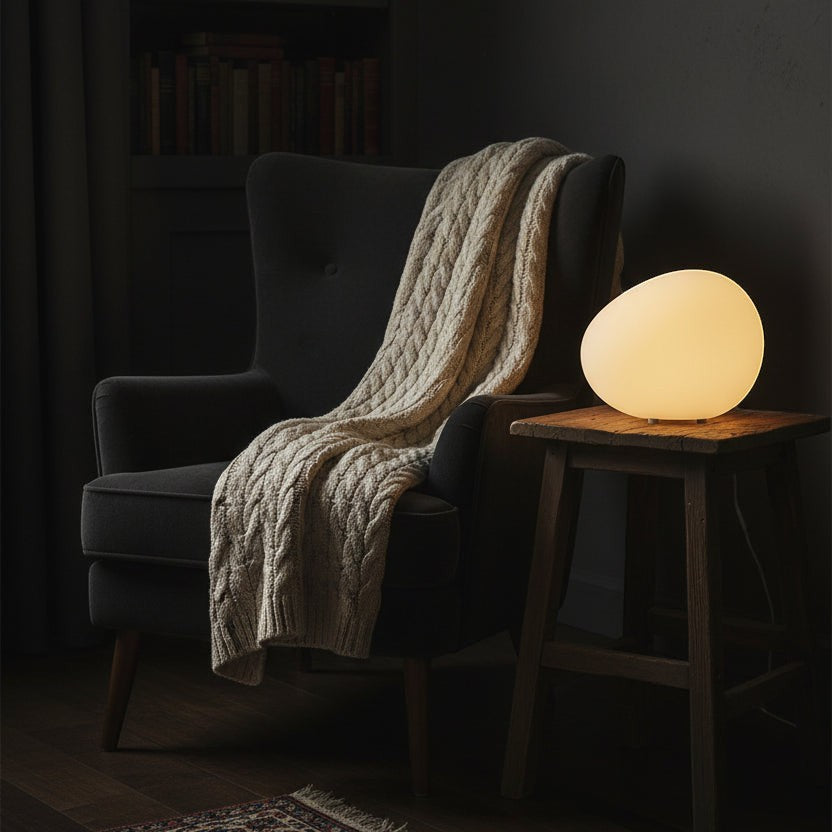 Glow & Drift Zen Riverstone Ambient Lamp with a soft, glowing frosted acrylic finish on a rustic wooden side table.