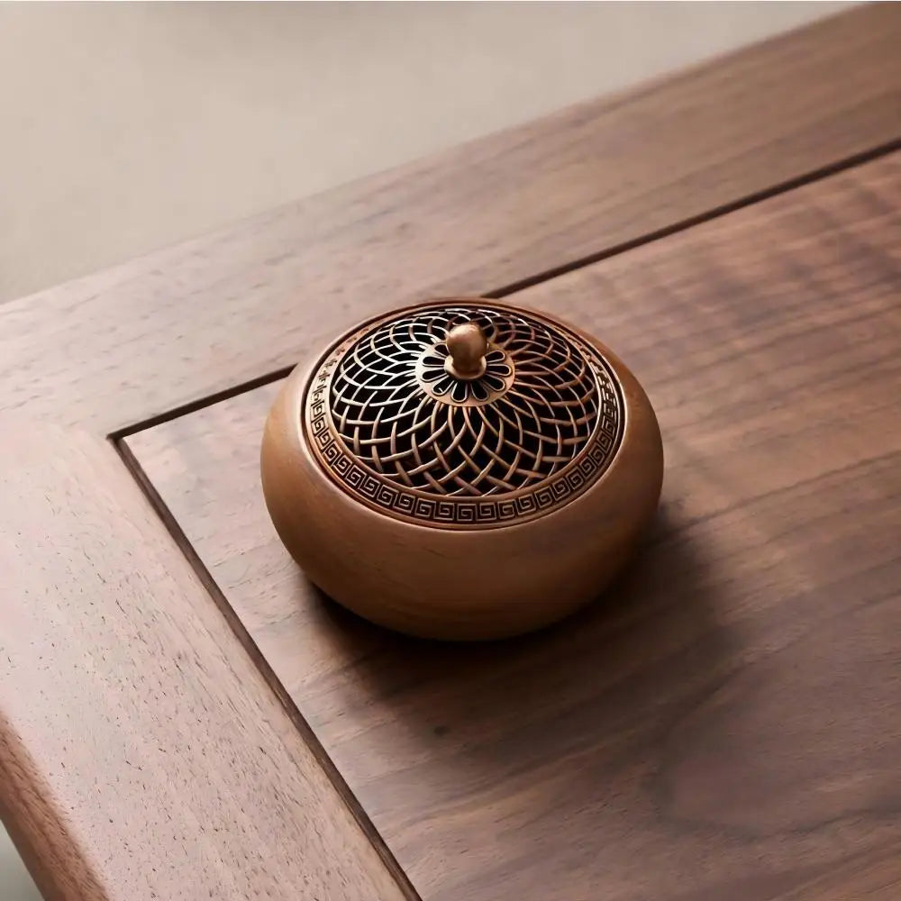 The Heritage round solid wood incense burner with its lid closed, creating a clean, minimalist decorative statement on a dark walnut table.
