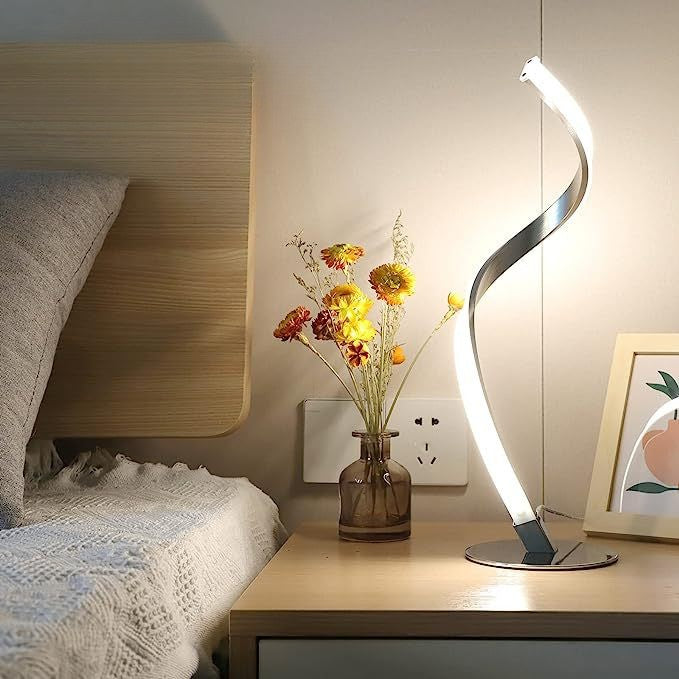 Minimalist bedroom nightstand styling inspiration featuring a warm spiral accent light next to a vase of dried flowers.