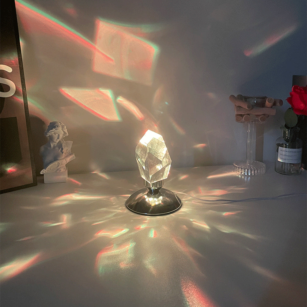 The Aether Crystal Projector lit on a white surface, creating a calming, immersive sensory environment by casting pastel and warm-toned geometric shadows across the room.