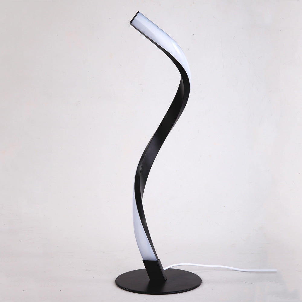 Contemporary serpentine spiral table lamp featuring a luxury matte black finish and a round minimalist base.