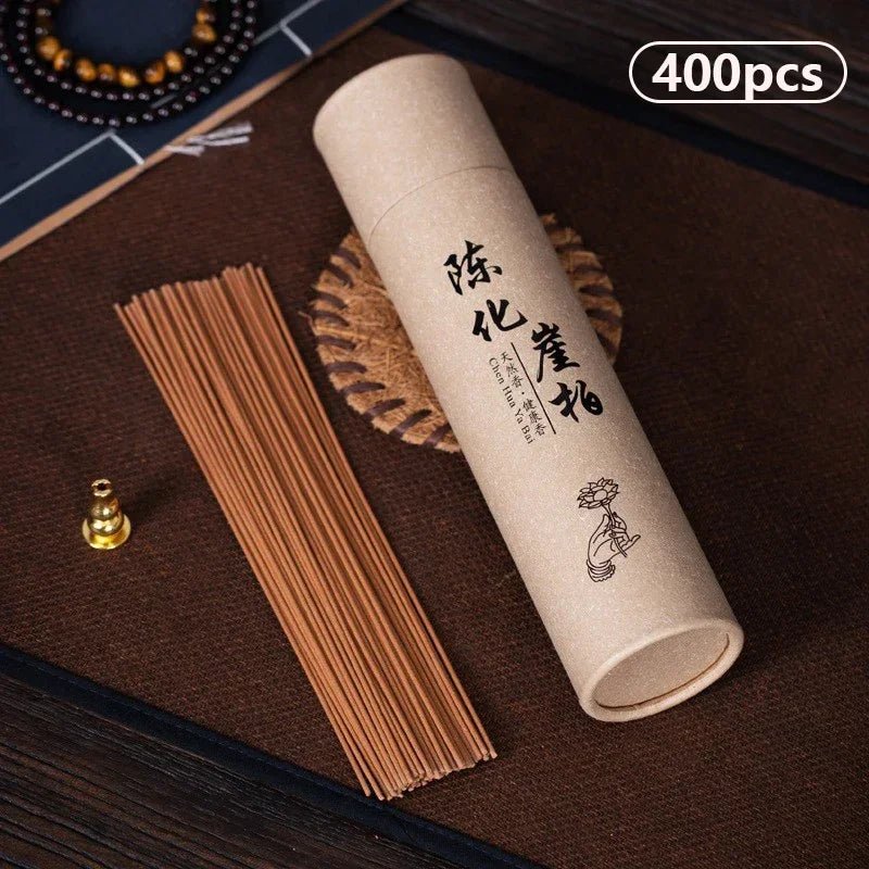 Tube of Thuja (Chen Hua Ya Bai) incense sticks on a dark mat.