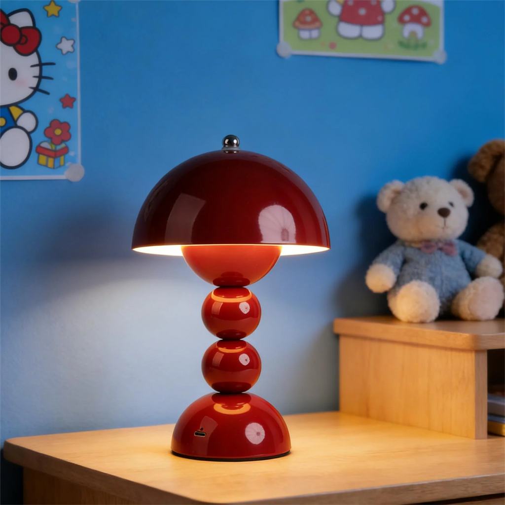 The red Totem cordless mood light glowing warmly on a wooden bedside table in a vibrant blue bedroom next to a plush teddy bear.