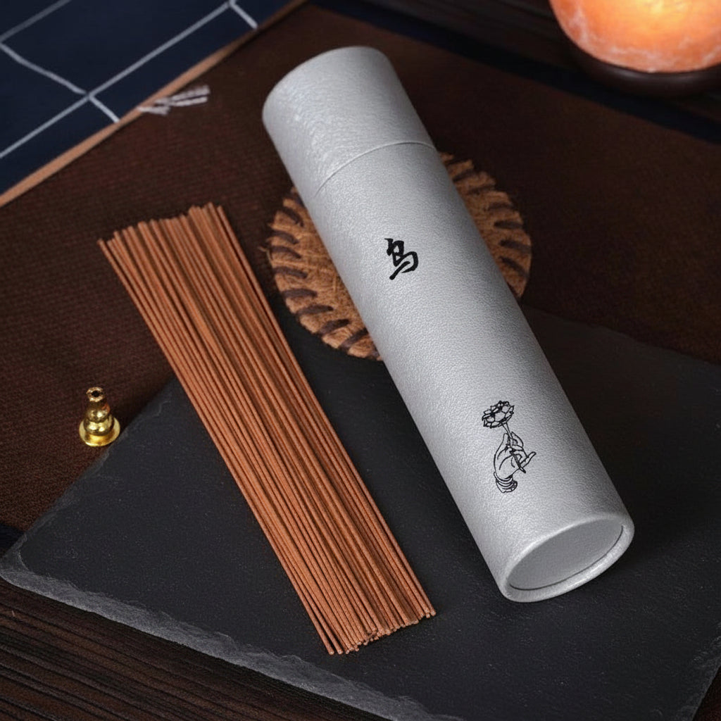 Tube of Wu Eaglewood (Wu Chen Xiang) incense sticks on a dark mat.
